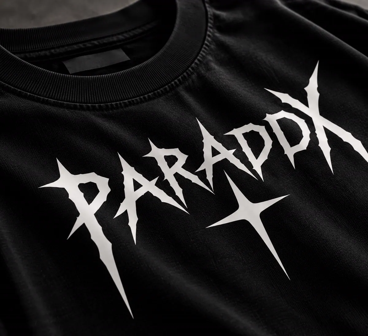 Close-up of white spiky PARADOX vinyl lettering on black fabric